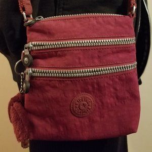 Maroon Kipling crossbody bag with big furry monkey
